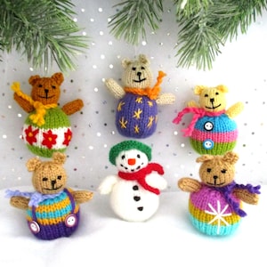 May include: Six handmade knitted ornaments, including a snowman and five bears. The ornaments are decorated with colourful stripes, stars, and flowers.