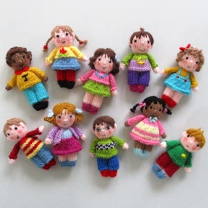 May include: A collection of ten knitted dolls, each with unique clothing and facial features. The dolls are all different colours and have different hairstyles.