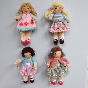 May include: Four knitted dolls with brown and blonde hair wearing colorful dresses and holding jump ropes. The dolls are all wearing different outfits and have different hairstyles.