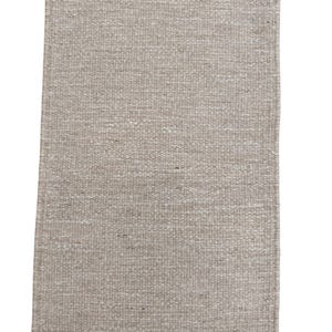 K&ouml;nnte beinhalten: Ein rechteckiger Webteppich in einer neutralen Farbpalette aus Beige und Off-White. Der Teppich weist eine gleichm&auml;&szlig;ige, dicht gewebte Textur auf und ist an beiden k&uuml;rzeren Seiten mit kurzen, geraden Fransen versehen.