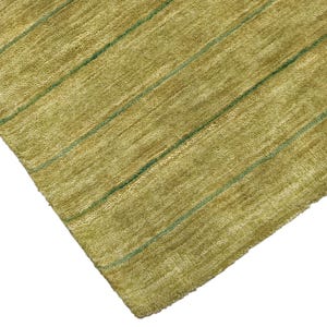May include: A rectangular area rug featuring a textured, olive-green pile surface. The rug is decorated with a series of thin, parallel dark green stripes that run diagonally across the fabric, creating a simple linear pattern throughout the piece.