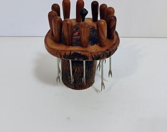Se trata de un juego de soportes para tenedores de cóctel hechos a mano en madera de olivo.