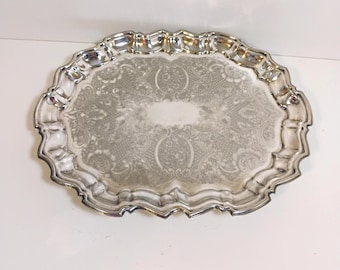 silver plate oval ornate tray with a scalloped edge and footed base