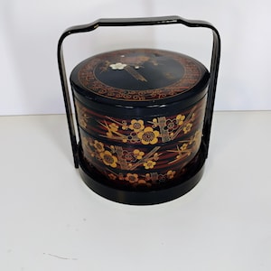 May include: A white ceramic mug with a black handle and the text "But First, Coffee" in a handwritten style. The mug is on a white surface. The mug is approximately 4 inches tall.