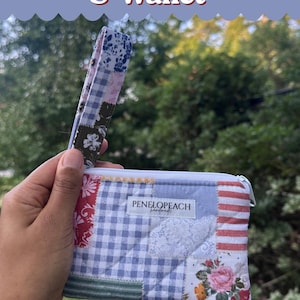 May include: A rectangular patchwork wristlet and wallet featuring a variety of fabric patterns including blue gingham, red stripes, and floral prints. A white label with the text PENELOPEACH handmade is centered on the front. It has a matching wrist strap.