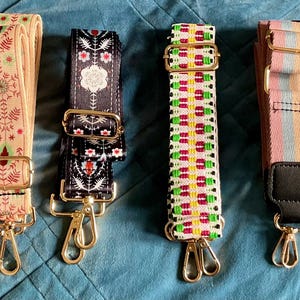 May include: Eight patterned bag straps with gold-coloured metal clasps. Designs include polka dots, floral, and geometric patterns in various colours. Each strap is designed to attach to a bag, offering a stylish accessory.