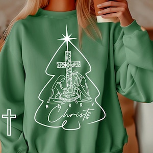 May include: Green sweatshirt with a white design of a Christmas tree with a star on top, a cross, and the words "Merry Christmas".