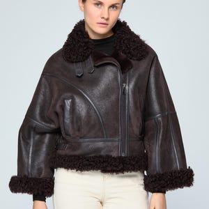 Woman wearing an authentic brown B3 shearling aviator jacket with thick natural sheepskin collar and custom fit design.