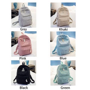 May include: A collection of corduroy backpacks in various colors: grey, khaki, pink, blue, black, and green. Each backpack has a front pocket, adjustable straps, and a top handle. The image displays the backpacks on a bed.