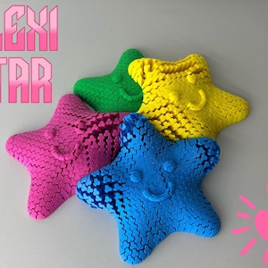 Puede incluir: Cuatro juguetes con forma de estrella hechos de pequeñas esferas conectadas. Las estrellas son de color rosa, azul, verde y amarillo. Cada estrella tiene una cara sonriente. El texto "FLEXI STAR" está en letras rosas en la esquina superior izquierda de la imagen.