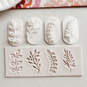 May include: A white silicone mould with six different leaf designs. The mould is used for creating decorative elements for cakes, cookies, or other baked goods.