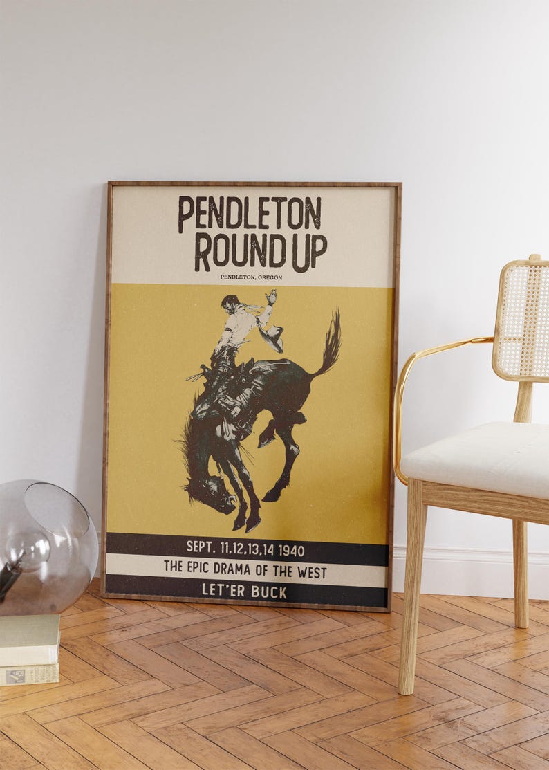 May include: Framed vintage poster for the Pendleton Round-Up rodeo event. The poster features a cowboy riding a bucking bronco, set against a yellow and black background. Text includes "Pendleton Round Up" and event details from 1940.