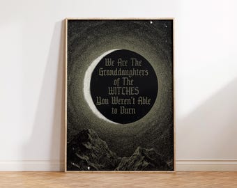 May include: Framed art print featuring a dark, celestial design with a crescent moon and mountains. The print has the text: "We Are The Granddaughters of The Witches You Weren't Able to Burn." The artwork is in a wooden frame.