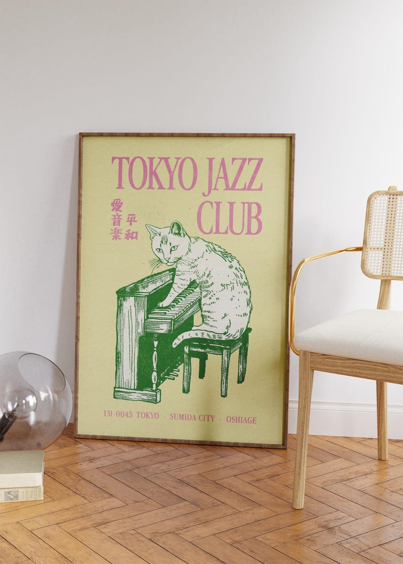May include: A framed poster with a vintage aesthetic. The poster features a white cat playing a green piano, with the words "TOKYO JAZZ CLUB" in pink. Additional text includes Japanese characters and location details.