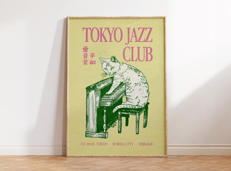 May include: A framed poster with a vintage aesthetic. The poster features a green and white illustration of a cat playing a piano, with the text "TOKYO JAZZ CLUB" in pink. Additional Japanese text and location details are also included.