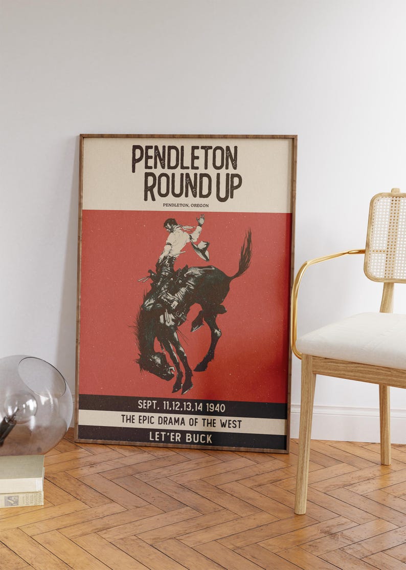 May include: Framed vintage poster for the Pendleton Round-Up rodeo event. The poster features a cowboy riding a bucking bronco against a red background. Text includes "Pendleton Round Up" and event details.