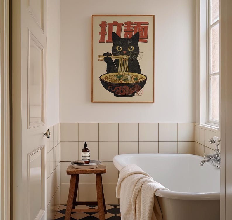 May include: A black cat with a bowl of noodles in front of it. The cat is looking at the camera and has a playful expression. The bowl of noodles is in a white bowl with a red rim. The image is in a wooden frame and has the Japanese characters "猫麺" written on it.