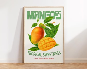 May include: A framed print featuring a vintage-style illustration of mangoes. The artwork showcases a whole mango and a sliced mango, with green leaves. The text "MANGOES" and "TROPICAL SWEETNESS" are displayed in green.