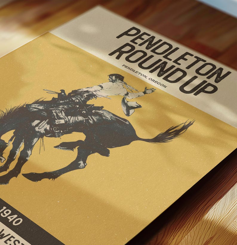 May include: A vintage poster with the text "PENDLETON ROUND UP" and "PENDLETON, OREGON" in bold, black font. The poster features a black and white illustration of a rodeo cowboy on a bucking bronco. The background is a tan color.