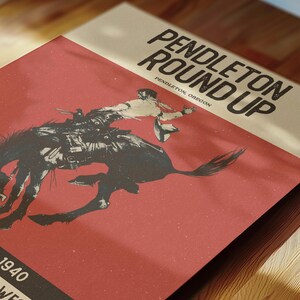 May include: A vintage poster with the text "PENDLETON ROUND UP" and "PENDLETON, OREGON." The poster features a black and white illustration of a cowboy riding a bucking bronco against a red background. The year "1940" is also visible.