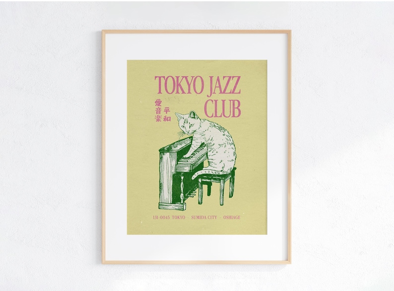 May include: Framed art print featuring a cat playing a piano. The print has the words "TOKYO JAZZ CLUB" in pink, with Japanese text above the cat illustration. The cat is white with gray markings, and the piano is green.