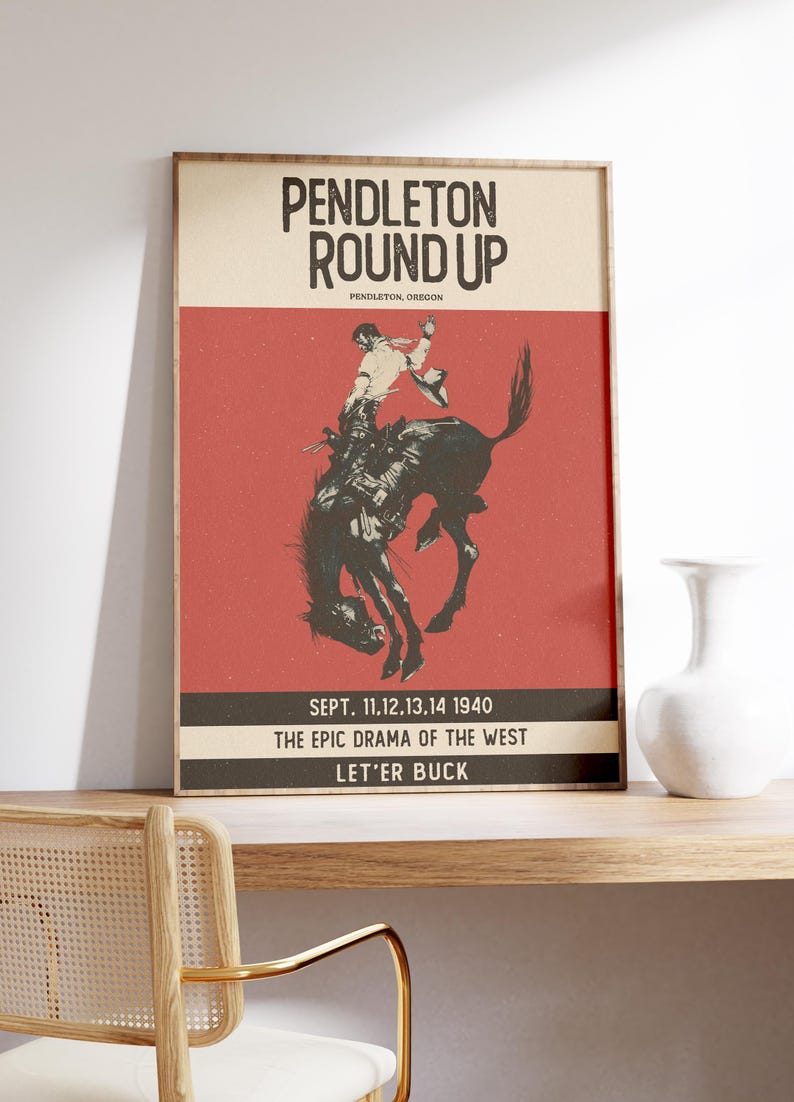 May include: A framed vintage poster advertising the Pendleton Round Up rodeo. The poster shows a cowboy on a bucking bronco against a red backdrop. Text includes "Pendleton Round Up," "Pendleton, Oregon," and event details from 1940.