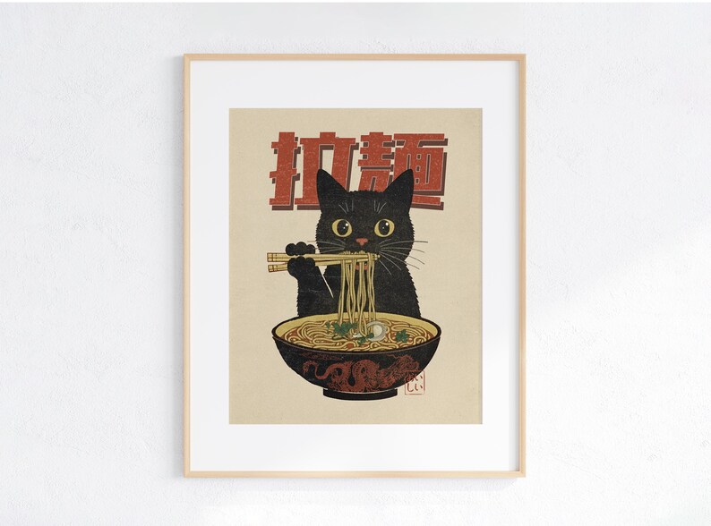 May include: A black cat with green eyes is eating ramen noodles from a bowl with chopsticks. The bowl is red and white with a dragon design. The text "拉麺" is written in red on a white background.