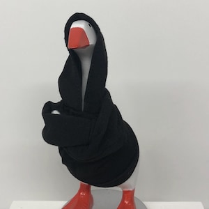 May include: A whimsical goose figurine with a white body, a red beak and feet, and a black hooded robe. The figurine is standing on a silver base. The goose is a unique decorative item.
