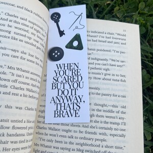 May include: A bookmark with a black and white quote that reads "When you're scared but you do it anyway, that's brave." The bookmark is decorated with a key, a needle and thread, and three green buttons.