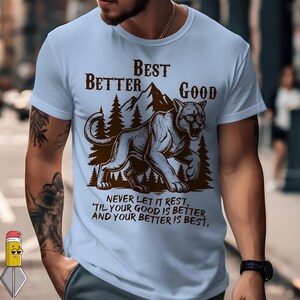 Peut inclure: T-shirt bleu clair avec un motif de montagne et de cougar. Le texte marron sur le t-shirt dit "BEST BETTER GOOD" et "NEVER LET IT REST, 'TIL YOUR GOOD IS BETTER AND YOUR BETTER IS BEST,".