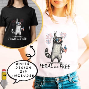 以下が含まれることがあります： サングラスをかけ、小さなアメリカ国旗を持ったアライグマのグラフィックが描かれた白いTシャツ。アライグマは、花火とともにピースサインをしています。「FERAL but FREE」の文字が下に印刷されています。