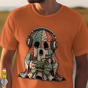 Peut inclure: T-shirt orange avec un motif de fantôme de dessin animé. Le fantôme porte un casque et tient une manette de jeu verte. Le motif du fantôme est un patchwork de motifs rouges, bleus et blancs. Le t-shirt est de couleur orange unie.