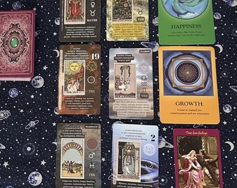 May include: A tarot card spread with ten cards laid out on a dark blue fabric with a white star pattern. The cards are from the "The Wild Unknown" tarot deck. The cards are: The Empress, 5 of Pentacles, The Chariot, 19 The Sun, Clarity, Growth,  The World, 2 of Pentacles, and True Love Feelings.