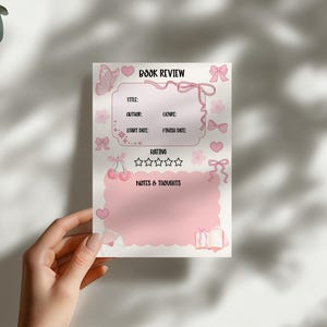 Puede incluir: Una hoja de revisi&oacute;n de libro rosa con elementos decorativos. La hoja incluye secciones para t&iacute;tulo, autor, g&eacute;nero, fechas, calificaci&oacute;n y notas. Adornada con lazos, corazones y una mariposa.