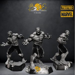 Puede incluir: Tres figuras de acción grises de Hulk en diferentes poses, de pie sobre bases negras con un borde plateado. Las bases presentan un logotipo de abeja con el texto "BOE FIGURE" y "TESTED MARVEL".