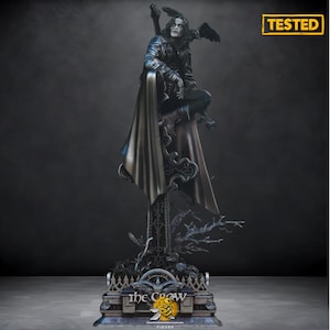 Puede incluir: Figura detallada de The Crow, un personaje de la película, posada sobre una base decorativa. La figura viste un abrigo y pantalones negros, con un cuervo posado en el hombro. La base presenta el logotipo de la película y la palabra "FIGURE".