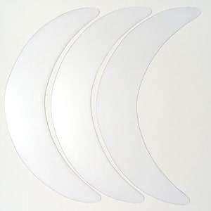 May include: Three white crescent-shaped eye patches for under-eye care.