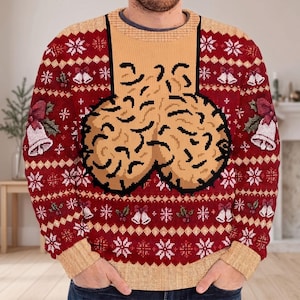 Könnte beinhalten: Ein roter, langärmeliger Strickpullover mit einem wiederkehrenden Muster aus weißen Schneeflocken und Glocken mit Stechpalmen. In der Mitte der Brust befindet sich ein großes, beiges, texturiertes Grafikdesign mit schwarzen Umrissen.