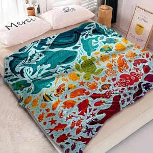 May include: A colorful blanket featuring an ocean-themed design. The blanket showcases various marine life, including whales, turtles, and fish, in shades of blue, green, orange, and red. The blanket is made of soft material and is suitable for a bed or couch.