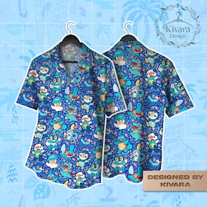 May include: Blue short-sleeved button-down shirt featuring a repeating pattern of cartoon characters in shades of blue, white, and yellow. The shirt is displayed on a black hanger. The text "DESIGNED BY KIVARA" is visible on the bottom right.
