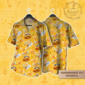 May include: Yellow short-sleeved shirt with a bee and honeycomb pattern. The shirt features a button-down collar and is displayed on a black hanger. The design includes cartoon bees and geometric honeycomb shapes. The text "DESIGNED BY KIVARA" is visible.