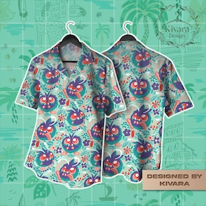 May include: Short-sleeved button-down shirt with a whimsical pattern of purple, teal, and red cartoon creatures and flowers. The shirt is displayed on a black hanger against a teal background. The design is repeated on the front and back of the shirt. The words "Designed by Kivara" are visible.