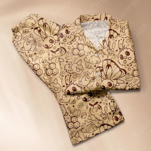 K&ouml;nnte beinhalten: Beige Pyjama-Set mit einem sich wiederholenden braunen Cartoon-Charakter-Muster. Das Set enth&auml;lt ein Hemd mit Kragen und Kn&ouml;pfen sowie eine passende Hose. Das Design zeigt verschiedene Kreaturen, Schmetterlinge und florale Elemente.