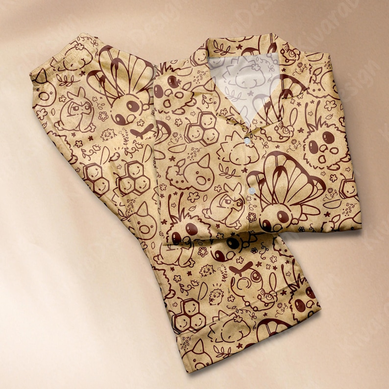 K&ouml;nnte beinhalten: Beige Pyjama-Set mit einem sich wiederholenden braunen Cartoon-Charakter-Muster. Das Set enth&auml;lt ein Hemd mit Kragen und Kn&ouml;pfen sowie eine passende Hose. Das Design zeigt verschiedene Kreaturen, Schmetterlinge und florale Elemente.