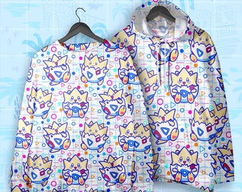 May include: A white sweatshirt and hoodie featuring a repeating pattern of a cartoon character in a blue, yellow, and red color scheme. The design includes geometric shapes like circles and triangles. The clothing is displayed on black hangers.