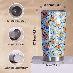 K&ouml;nnte beinhalten: Ein Edelstahlbecher mit einem bunten Muster aus Zeichentrick-Dinosauriern, Sternen und Spielkarten. Der Becher ist 17,2 cm hoch und hat einen Durchmesser von 7 cm. Der Text auf dem Becher lautet "304 Stainless Steel", "Large Diameter" und "Stainless Steel Bottom".
