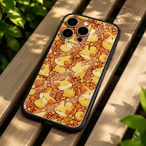 May include: A black smartphone case featuring a repeating pattern of yellow fox-like creatures and orange flowers on a dark red background. The case has a cutout for a triple camera system and a small logo in the corner that reads Kivara Design.
