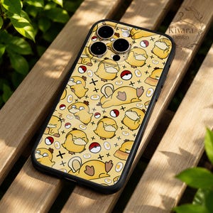 Könnte beinhalten: Eine schwarze Handyhülle mit einem wiederkehrenden Muster aus gelben Psyduck-Figuren, rot-weißen Poké-Bällen und kleinen Spiegeleiern auf hellgelbem Hintergrund. Das Design enthält kleine schwarze Kreuzsymbole, die über die Fläche verteilt sind.