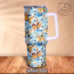 K&ouml;nnte beinhalten: Ein 1,18-Liter-Becher mit wei&szlig;em Griff und blauem Deckel. Der Becher hat ein sich wiederholendes Muster aus Zeichentrickdrachen, Spielkarten und Sternen. Der Text "Tumbler 40oz" ist unten aufgedruckt.