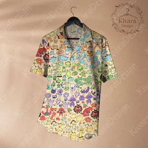 May include: Short-sleeved button-down shirt with a beige background and a colorful cartoon character pattern. The shirt is hanging on a black hanger. The shirt features a collared neckline and a relaxed fit.